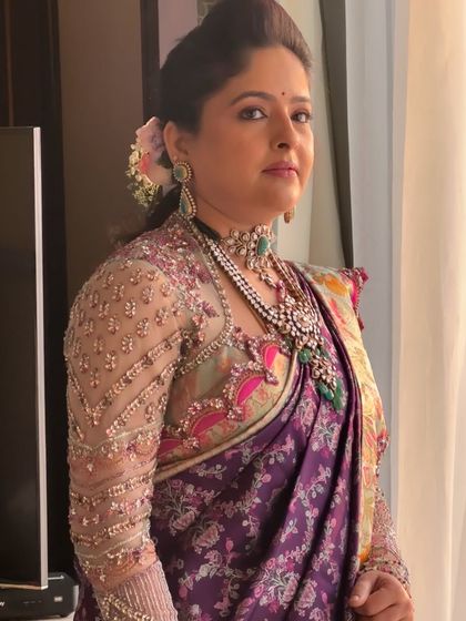 A side profile view that captures the soft hairstyle with a flower accent and the beautiful sheen on the skin.