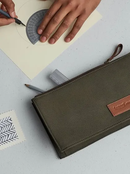 This flat lay for The Postbox tells the story of a creative professional. The canvas pouch is surrounded by stationery and design elements, placing the product within an aspirational lifestyle.