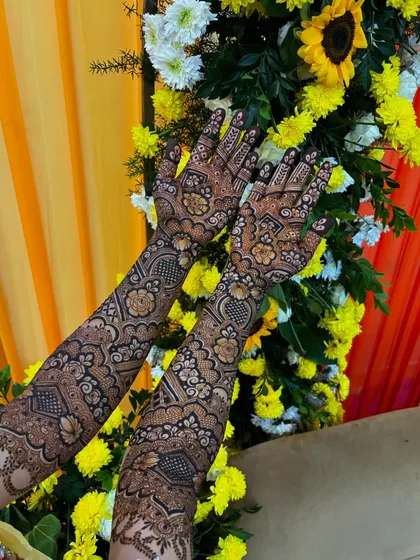 Another beautiful shot of Mariam's mehendi against a floral backdrop.