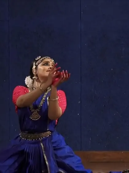 A seated pose showing an offering of flowers (pushpanjali), a traditional opening for many Bharatanatyam recitals. It is a gesture of reverence to the stage, the audience, and the divine.