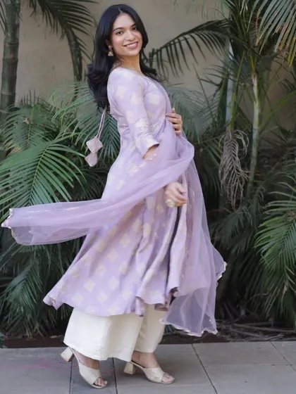 The sheer dupatta of this lavender Anarkali catches the breeze, creating a beautiful, dynamic portrait full of life and movement.