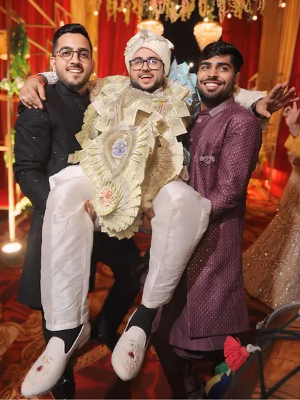 Love is patient, love is kind, love is married. The groom being playfully lifted by his friends, a moment of pure fun and camaraderie.
