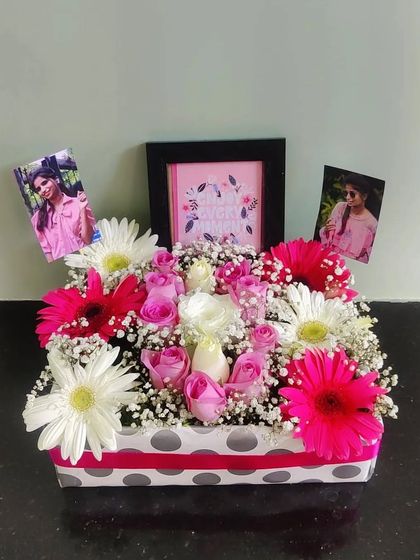 This arrangement shows how we can incorporate multiple personal elements, with two photos and a framed quote set amidst a colorful display of fresh flowers.