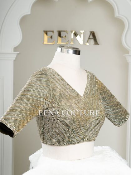 I designed this sage green raw silk blouse with geometric handwork for a timeless yet modern feel. The linear beadwork is complemented by custom floral tassels, making it a versatile piece for any occasion.