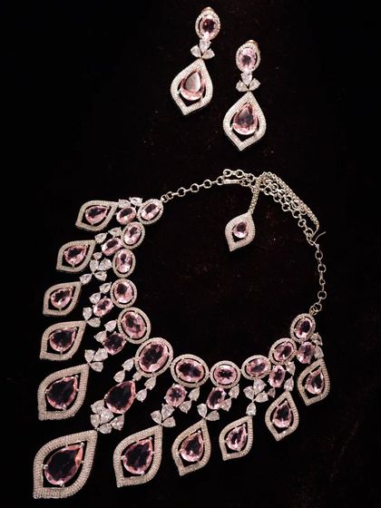 A designer necklace and earring set with pink stones. This is a very modern and high-fashion piece.