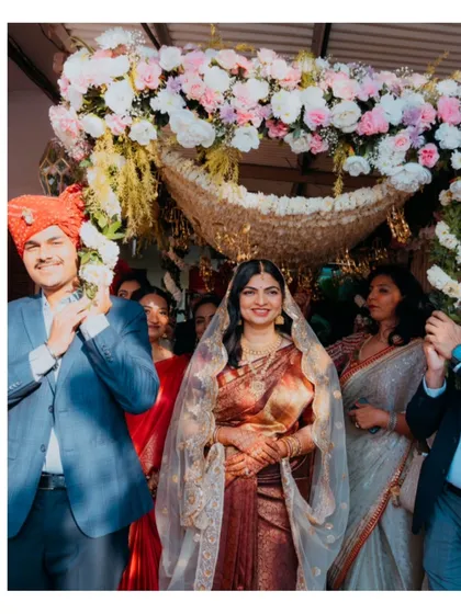 The breathtaking bridal entry. We capture the bride's radiant smile as she walks towards her future, framed by a beautiful floral canopy and the proud faces of her family, a pivotal moment in any wedding story.