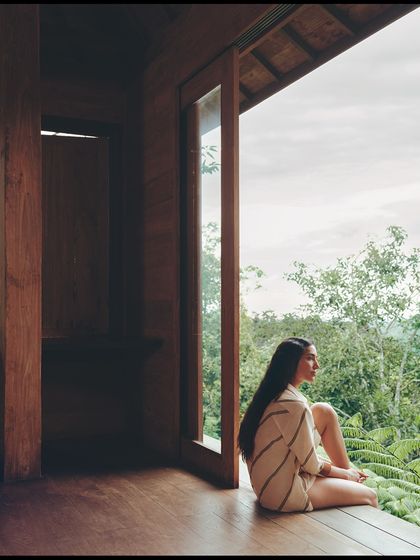 Contemplation by the window. The natural light and the simple, elegant lines of the tunic create a soft and tranquil mood.