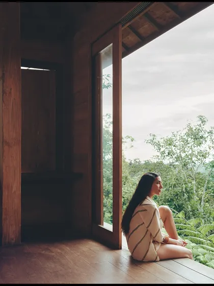 Contemplation by the window. The natural light and the simple, elegant lines of the tunic create a soft and tranquil mood.