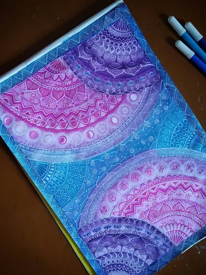 This is my 'Galaxy Mandala' series, where I blend intricate geometric patterns with the colors of deep space. Each section is carefully detailed with fine-line markers, transitioning from cosmic blues to vibrant purples and pinks to create a sense of depth and wonder.