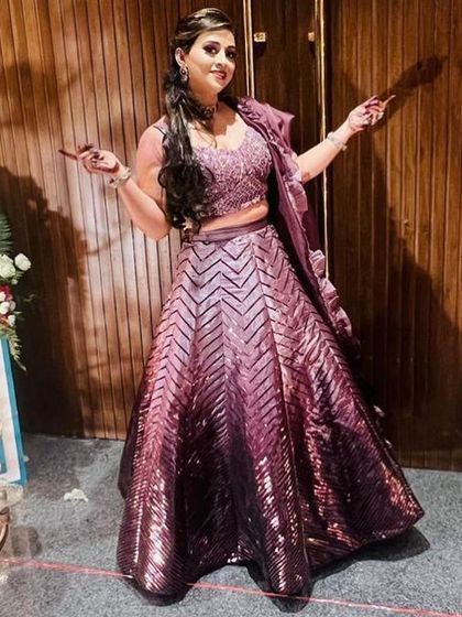 A client looking fabulous in a wine-colored lehenga with a geometric sequin pattern. This is a popular rental for cocktail parties and receptions.