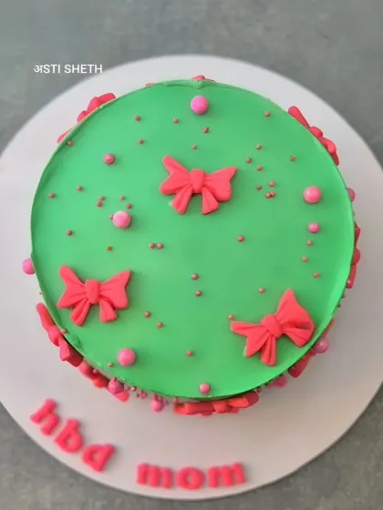 An overhead view of the bow-themed cake for mom, showing the vibrant green and pink colour combination.