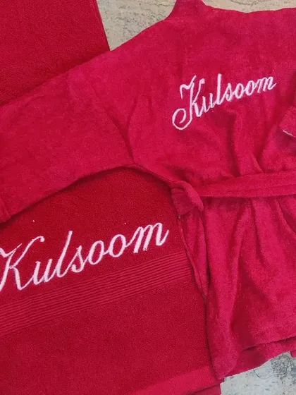 Little ones look so cute in their own personalized bathrobes! This vibrant red set includes a cozy toddler bathrobe and a matching bath towel, both embroidered with the name 'Kulsoom' in a lovely white script. It's a perfect gift to make bath time extra special.