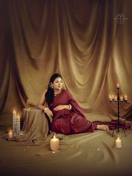A wide shot capturing the full, elegant setup with candles and drapery, where the mom-to-be is the picture of grace.