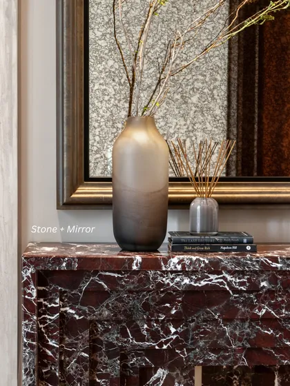 Stone + Mirror: A beautiful red marble console is paired with a framed mirror, creating layered reflections and a rich textural contrast.