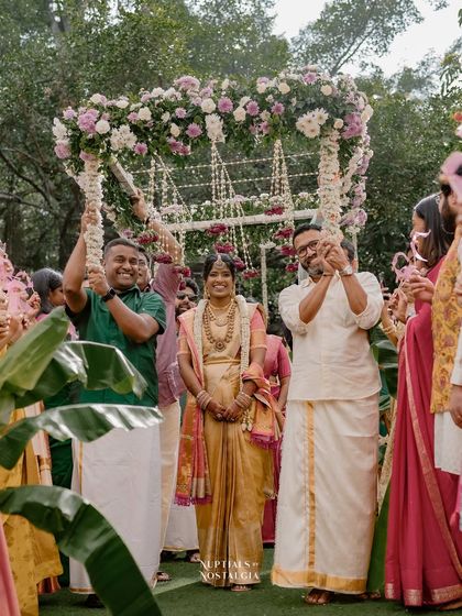 The bride makes her grand entrance under a canopy of fresh flowers, a beautiful tradition we love to accommodate.