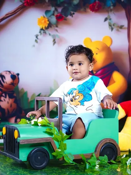 A thoughtful look from our little explorer as he sits in his green jeep, with Pooh bear right by his side.
