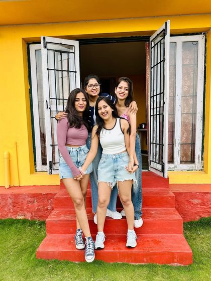 Friends posing at the entrance of our colorful homestay, ready for a day of adventure.