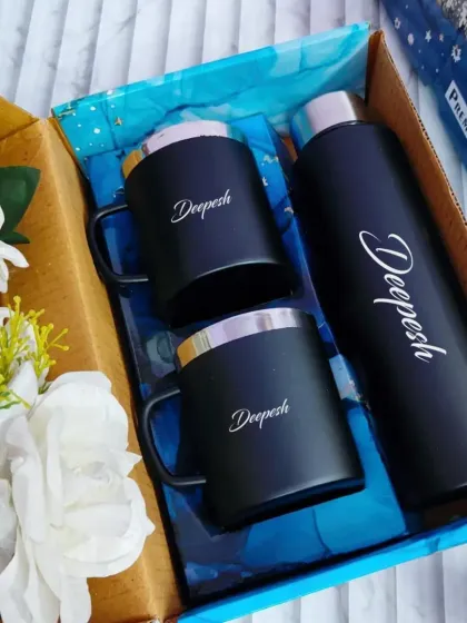 A matching set for a couple or friends. This gift box includes a personalized water bottle and two matching mugs, all in a sleek black and silver design.