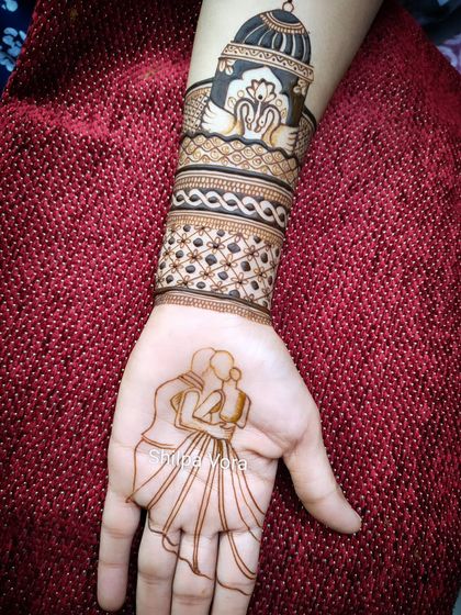 The initial outline of a couple's embrace on the palm. This shows the first, crucial step of placing the main figures before adding intricate details.