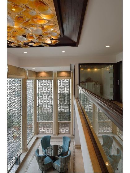 A showcase of cozy seating areas created in transitional spaces like landings and hallways, featuring elegant chandeliers and comfortable chairs.