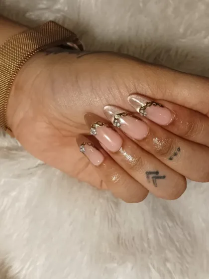 A still shot of the embellished French manicure, highlighting the intricate gold chain and rhinestone details.