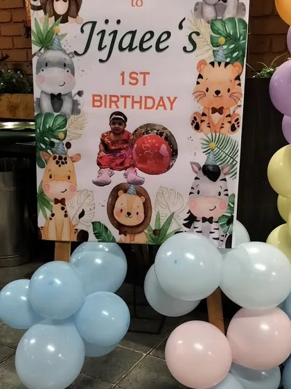 A personalized welcome sign for a jungle-themed first birthday, featuring cute animal graphics and a photo of the birthday boy.