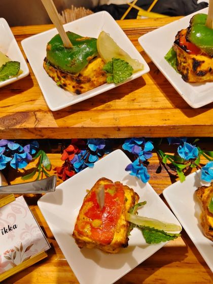 Our Stuffed Paneer Tikka is a feast of colors and flavors. Cubes of soft paneer are stuffed with a savory filling, marinated, and grilled, then served with a fresh mint chutney.