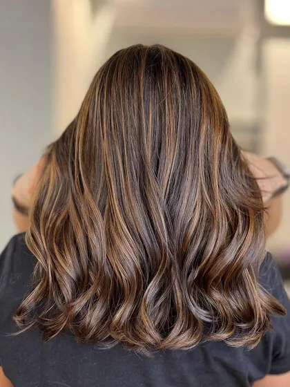 A cinnamon brown balayage gives a warm and spicy feel to the hair. The highlights are perfectly blended for a natural-looking result.