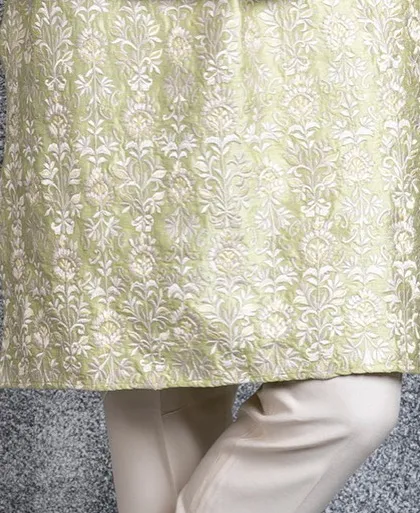 A detail shot of the hem of the mint green kurta, covered in matching Resham embroidery.