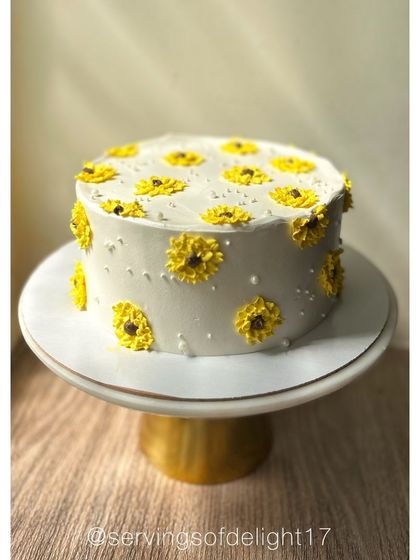 A cheerful cake covered in hand-piped sunflowers. This design is perfect for bringing a little bit of sunshine to any celebration.