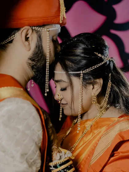 A tender moment with the groom kissing his bride's forehead.