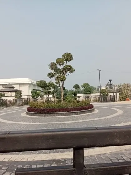 The entrance to this commercial establishment features a roundabout with a stunning topiary tree as the centerpiece. This creates a memorable first impression for all visitors.