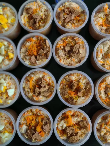 Meal prep day in the KuBi kitchen. Here’s a top-down view of our freshly cooked meals, portioned and ready for delivery. You can see the different toppings like boiled egg, soya chunks, and shredded carrots, showing the variety in each batch.
