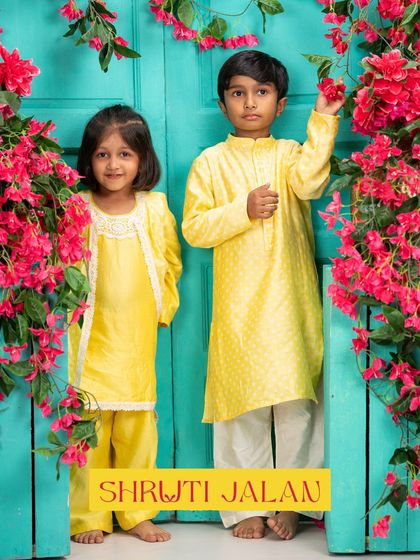 A brother and sister looking absolutely charming in a sunshine yellow coordinated set. I designed his kurta with a subtle dot print and her draped kurta with delicate lace trim for a touch of elegance.