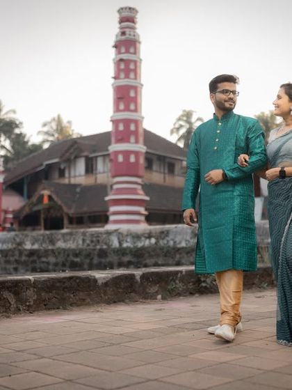 A couple in traditional attire walking through historic temple grounds in Goa. This captures a unique blend of cultural heritage and scenic beauty.