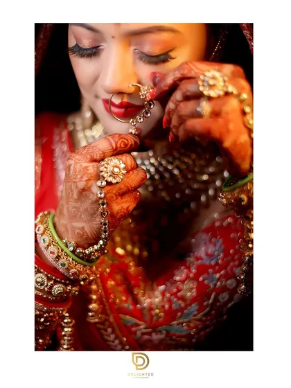 A close-up bridal portrait focusing on the intricate details of the bride's jewelry, makeup, and traditional nath, capturing her serene beauty on her wedding day.