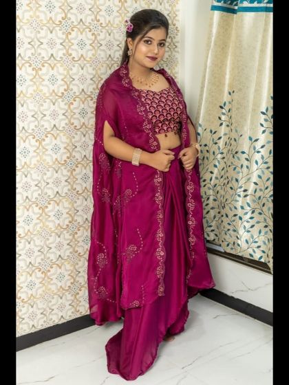 A full-length view of the magenta outfit, showing how the pre-draped skirt and cape create a graceful and modern silhouette.