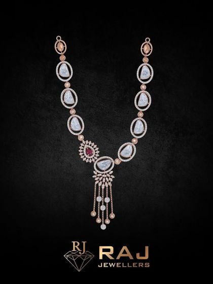 This long necklace, or 'haar,' features large, uncut-style stones interspersed with smaller red gems and CZ tassels. It is a grand, opulent piece perfect for layering or wearing as a standalone statement.