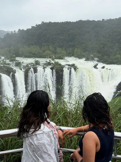 Two travelers admiring the breathtaking view of the falls from the viewpoint.