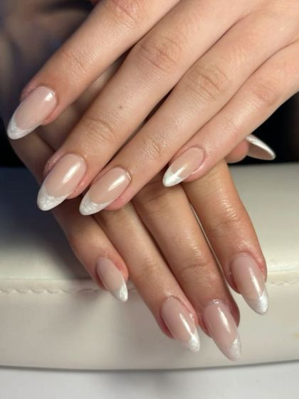 A modern take on a classic. This look features a subtle, shimmery white tip on a beautifully shaped almond nail, offering a fresh and elegant alternative to the traditional French manicure.