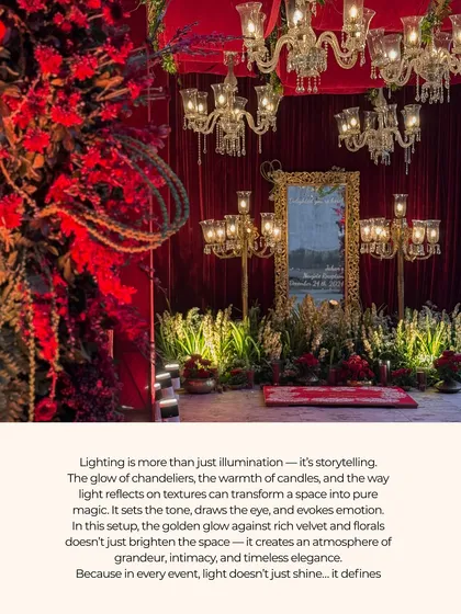A luxurious and opulent Sangeet setup. The space is defined by rich red velvet drapes, multiple crystal chandeliers, and lush florals, creating an atmosphere of timeless grandeur.