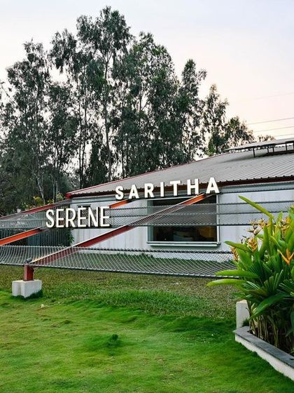 This image shows the tension-rod system that adds a dynamic, graphic element to the Saritha Serene facade. The vibrant red accents provide a pop of color against the building's neutral tones.