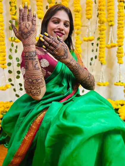 A beautiful shot of a bride at her mehndi ceremony, surrounded by flowers. Her hands are adorned with my intricate designs, ready for her big day.