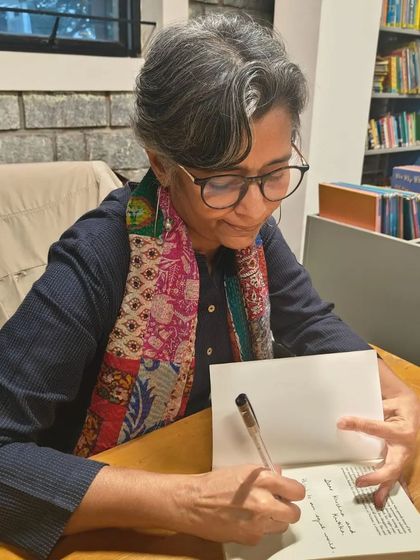 The author's personal touch. Mandira Shah carefully writing a personalized note in a book for one of our members.