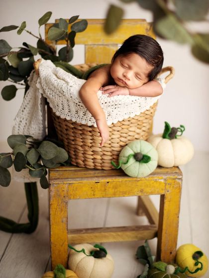 This little pumpkin is sleeping so soundly in a rustic basket. I use props like this vintage yellow chair and soft felted pumpkins to create a warm, autumnal feel for the portrait.