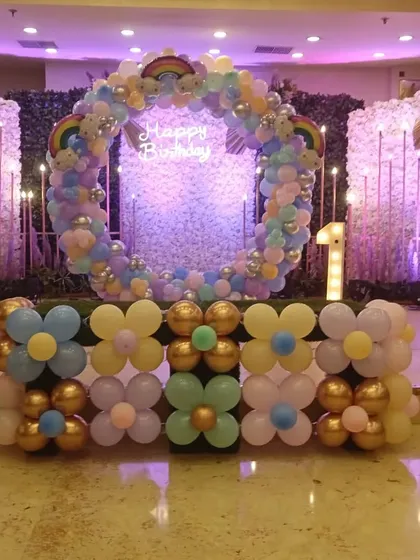 The main photo backdrop for the Boss Baby and Frozen party. It features a pastel balloon ring with a neon sign, a light-up number '1', and flower-shaped balloon clusters at the base.