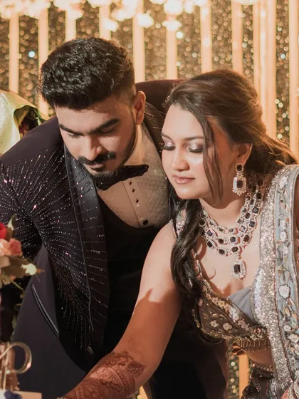 The cake-cutting ceremony. A close-up of the couple, focused and happy, during one of their reception's key moments.