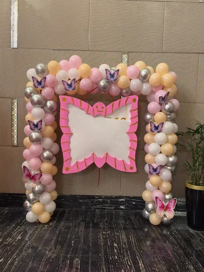 We created this butterfly-themed entrance arch to welcome guests. The arch is made of pink, peach, and silver balloons and is adorned with purple butterfly cutouts, setting the tone for the party right from the door.