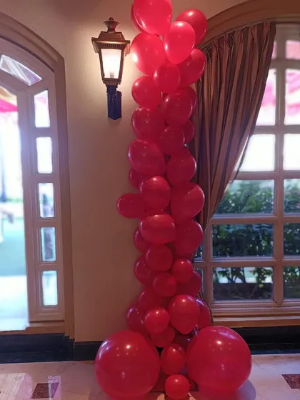 A close-up of a modern, organic-style balloon column in a striking all-red color scheme. This type of arrangement adds height and a dramatic pop of color to any corner of a room or entrance.
