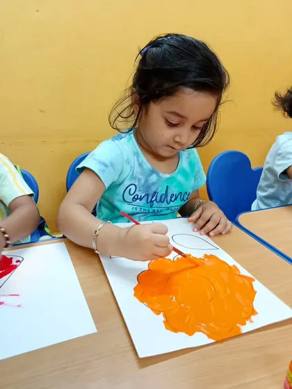 Look at the focus on her face. Painting is a wonderful activity that allows children to explore their creativity, improve concentration, and develop fine motor skills.